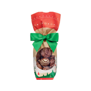 Sachet de chocolats assortis de Noël avec fenêtre transparente, décorations festives rouges et vertes et nœud en ruban vert, sur fond blanc.